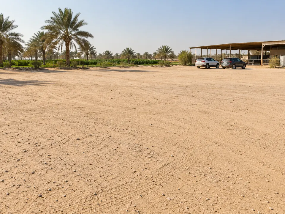 صورة توضيحية لساحة مواقف رملية بجانب منشأة ريفية